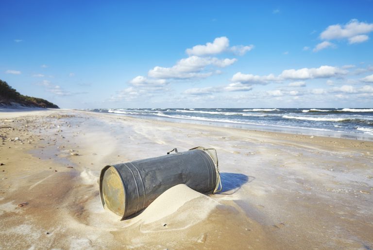 Trash can on a beach, environmental pollution concept